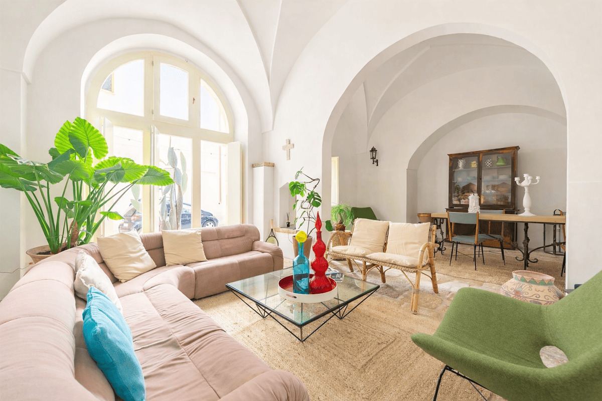 bright vaulted living room with large arched window at Dimora Alexanos historic house in Alessano Salento