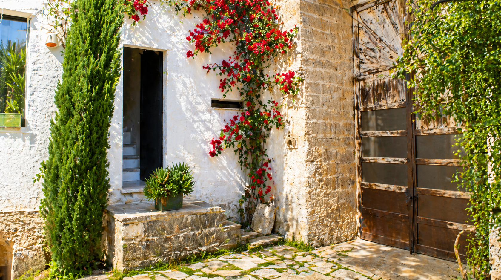 Corte d’ingresso della Dimora di German con portone in legno nel Salento